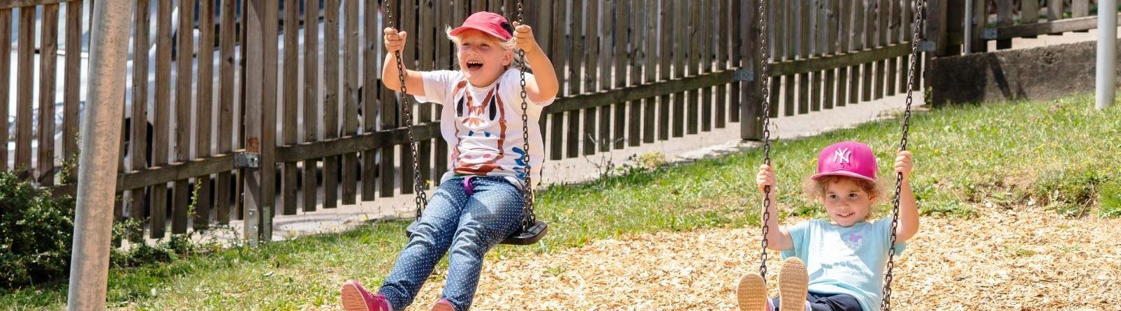 Kinderhaus Künzelsau. Foto Olivier Schniepp. Zwei Kinder schaukeln.
