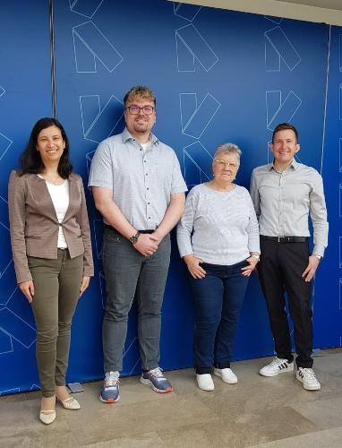 Bürgermeister Stefan Neumann, Roswith Deptner, Marc Finner und Slke Mittnacht stehen vor einer blauen Künzelsau Wand